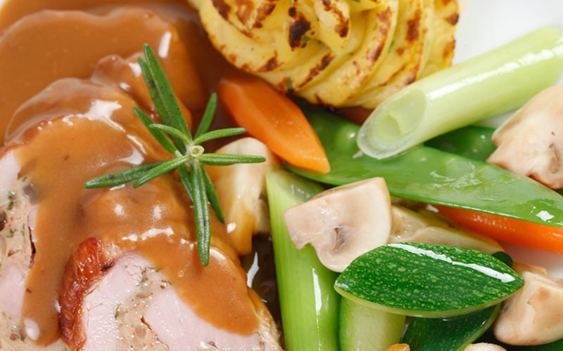 Gefülltes Leipziger Schweinefilet mit einer Pilzfarce in Rosmarinrahmsauce, frisches Marktgemüse  und geflämmte Spritzkartoffeln